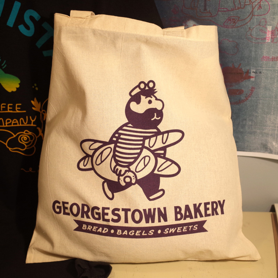 a side view of a character holding a bagel, a french loaf and two baguettes wearing a long sleeves stripped shirt